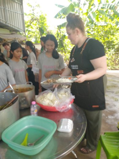 Woman serving food to children.