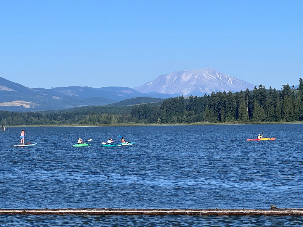 Guests of Silver Lake Resort kayaking and paddle boarding with Mount St. Helens in the background.