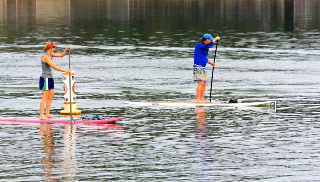 Stand up paddle boarders enjoying a quiet moment on the lake.
