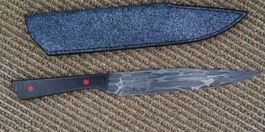A Dragonskin drop point Bowie with black Glass scales, red liners and pins. 