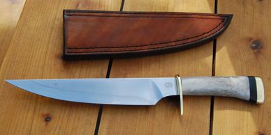 A w2 fighting style knife with a Buck and Brass handle. 