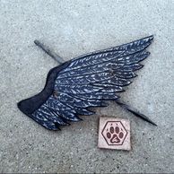 A carved leather ravens wing Barrette with a steel hairpin and Ashli's personal stamp. 