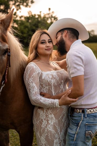Couple with a horse in a romantic outdoor setting.