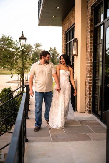Couple holding hands and walking outdoors.