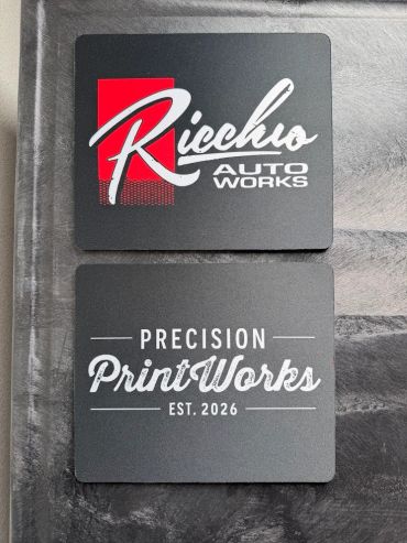 Two black square coasters with white and red text logos.