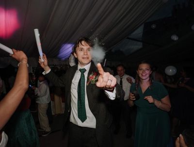 Man dancing and popping smoke bubble at a party.