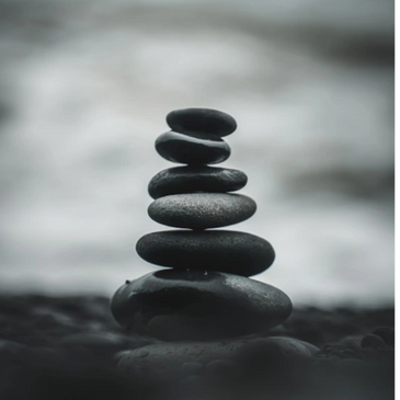 A stack of balanced smooth stones with a blurred background.