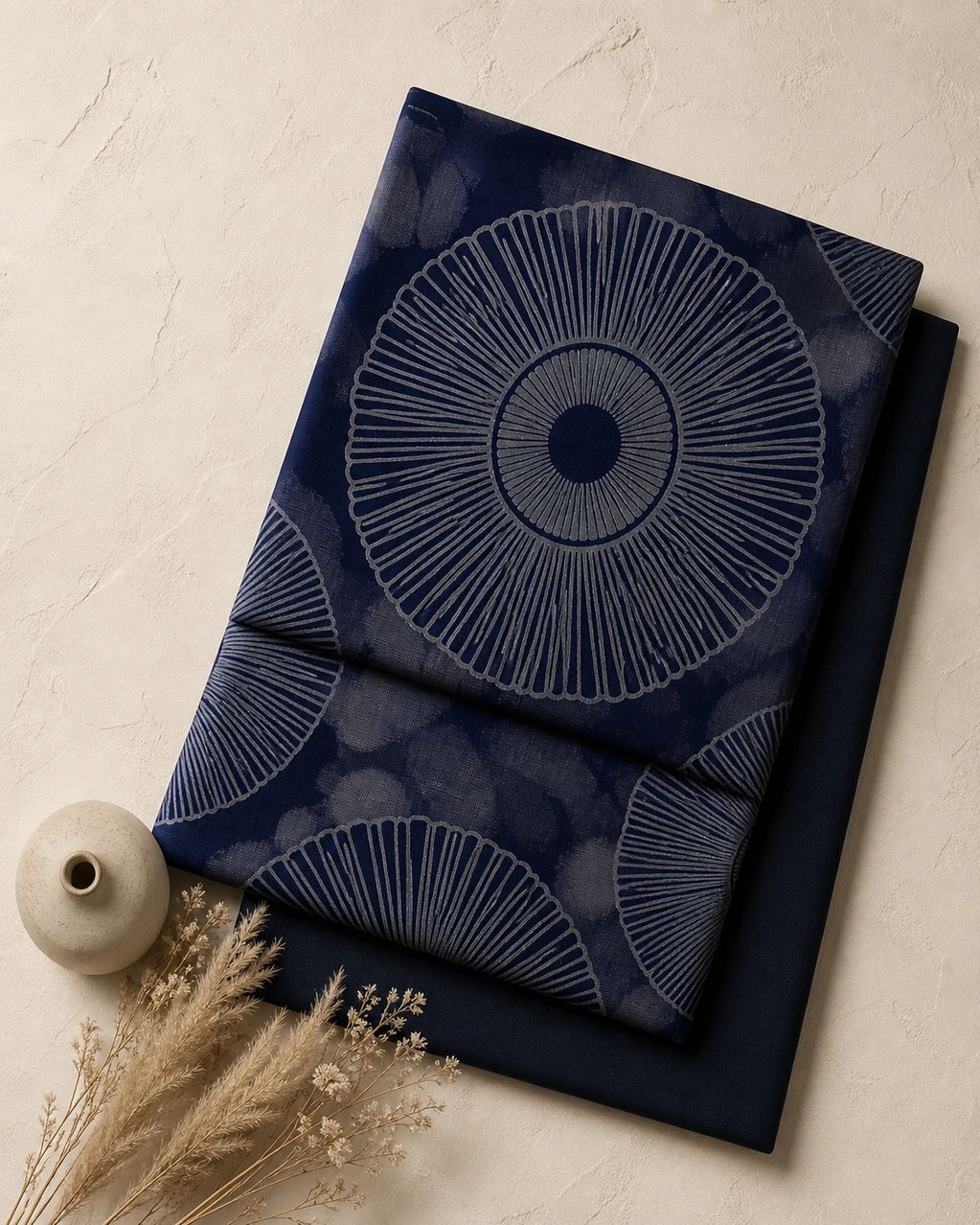 Dark blue fabric with circular patterns and a plain dark blue fabric underneath.