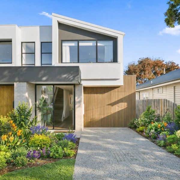 Modern two-story house with a garden and driveway.