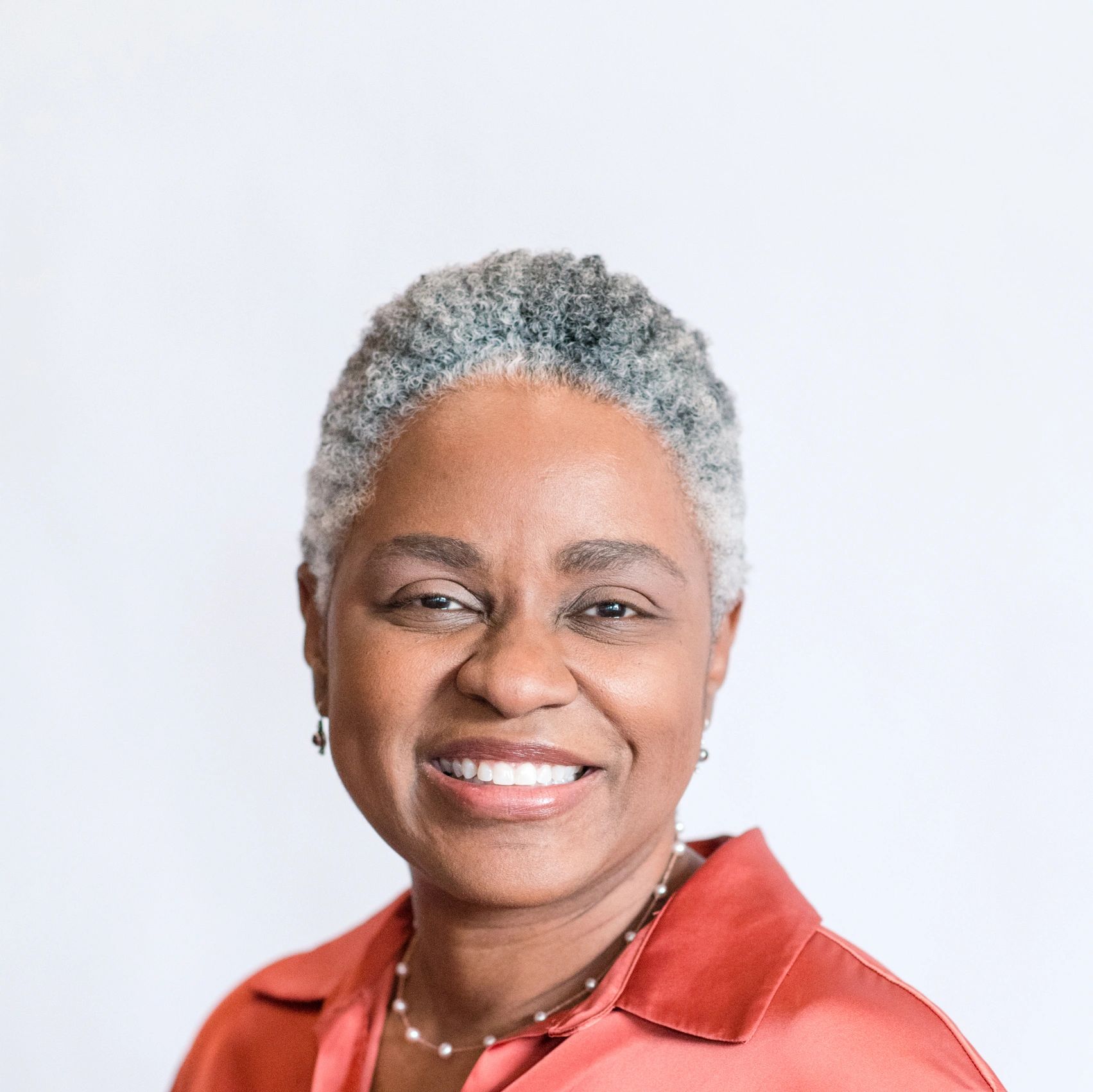 Woman smiling wearing an orange blouse