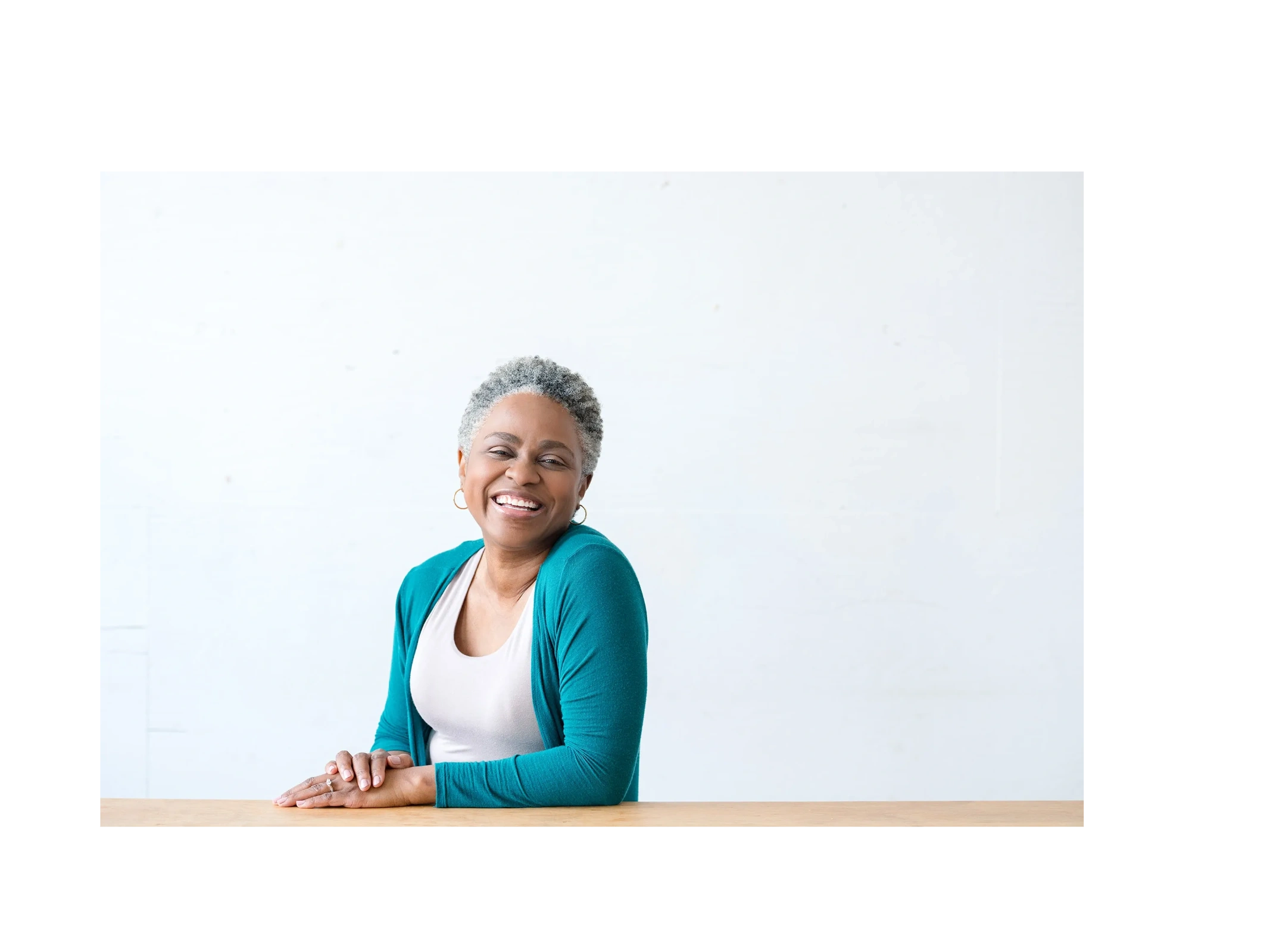 Owner sitting at a table smiling 
