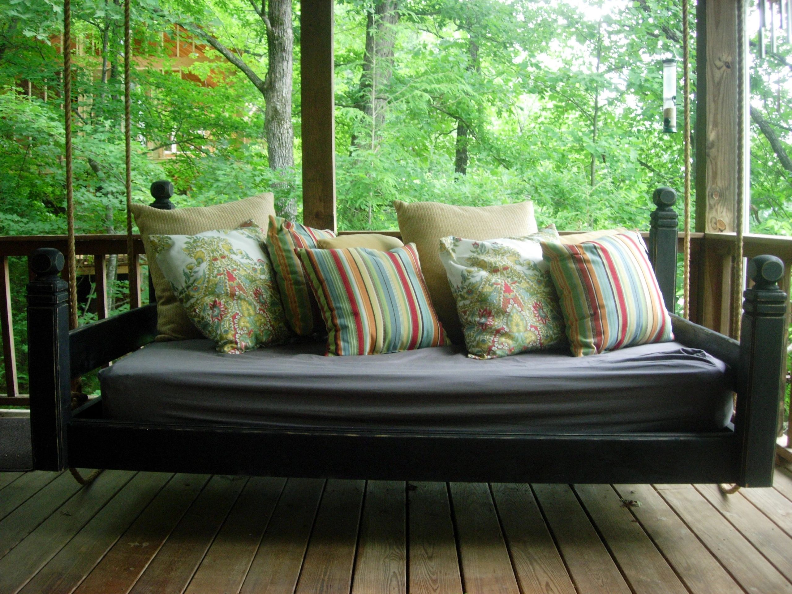 SwingBed with floral cushions on a screened porch