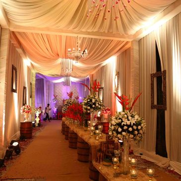 Elegant wedding aisle decorated with flowers and draped fabric.