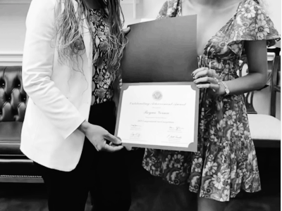 Two women holding a certificate together.