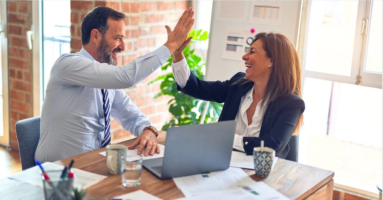 Male and female leaders doing a high 5.