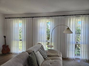Bright living room with white curtains and cozy sofa.