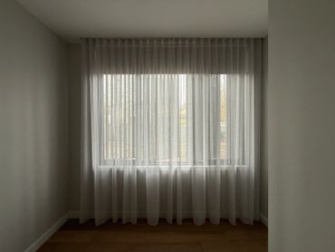 Window with sheer white curtains in a minimalist room.