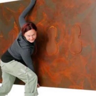 Person interacting with an abstract wall art featuring violin shapes.