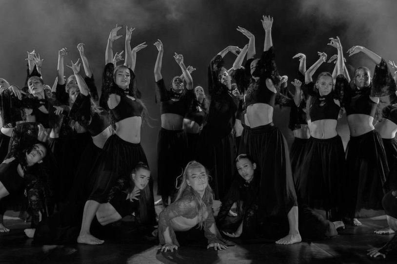 Group of dancers performing in coordinated poses.