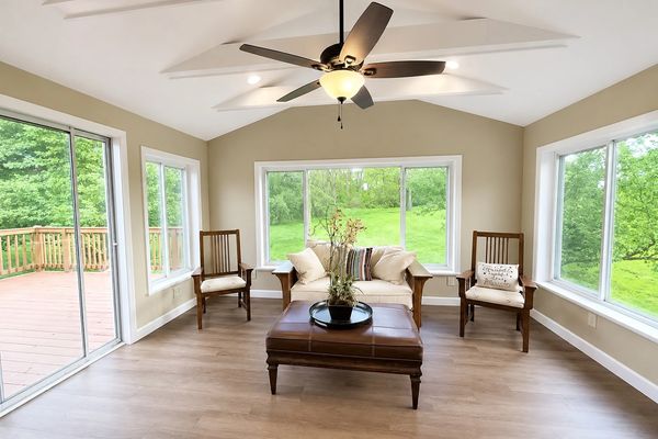 Bright living room with large windows and wooden furniture.