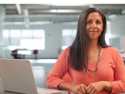 Woman in front of a computer in a modern open plan home.