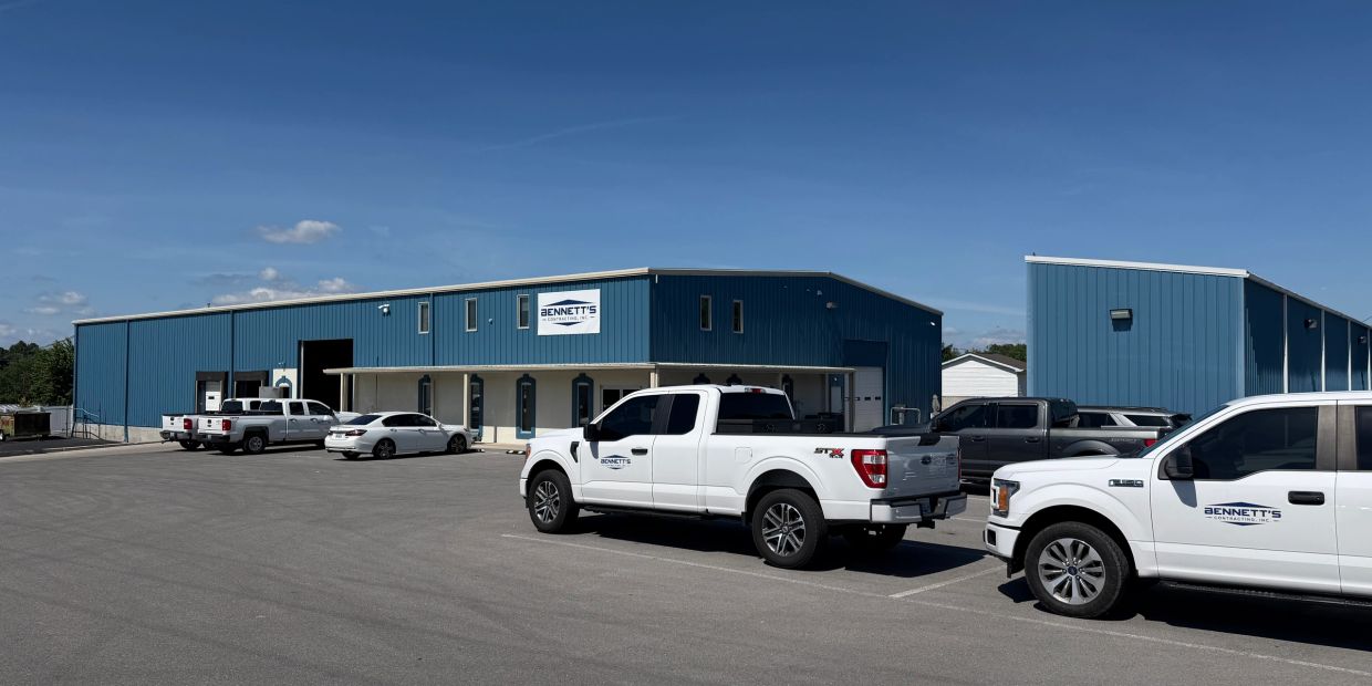 Commercial building with several parked pickup trucks.