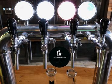 Beer dispenser tower on bar counter top with drip tray and under counter flash cooler