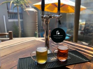 Beer dispenser tower on bar counter top with drip tray and under counter flash cooler