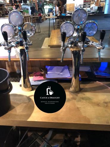 Beer dispenser tower on bar counter top with drip tray and under counter flash cooler