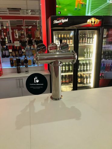 Beer dispenser tower on bar counter top with drip tray and under counter flash cooler