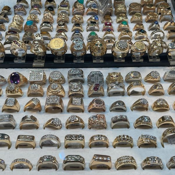 Collection of gold men's rings displayed at Oscar’s Estate Jewelry.