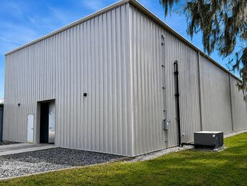 Modern industrial metal building under blue sky.