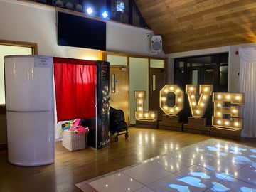 Indoor setup with enclosed photo booth and props.