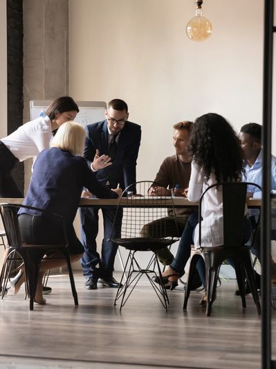 A diverse group of professionals engaged in a collaborative discussion around a table 