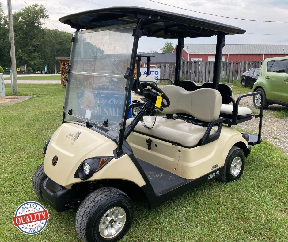 Beige Yamaha golf cart parked on grass with quality auto carts logo.