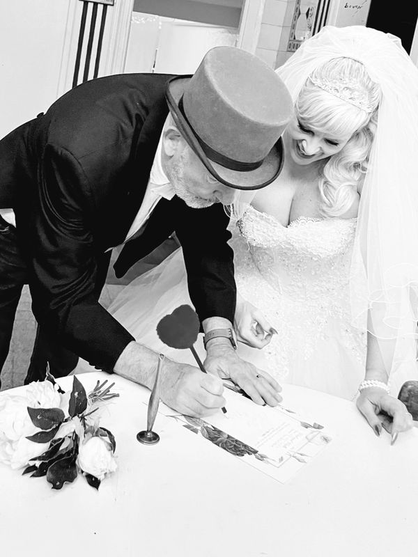Beautiful Bride and Groom sign paperwork.