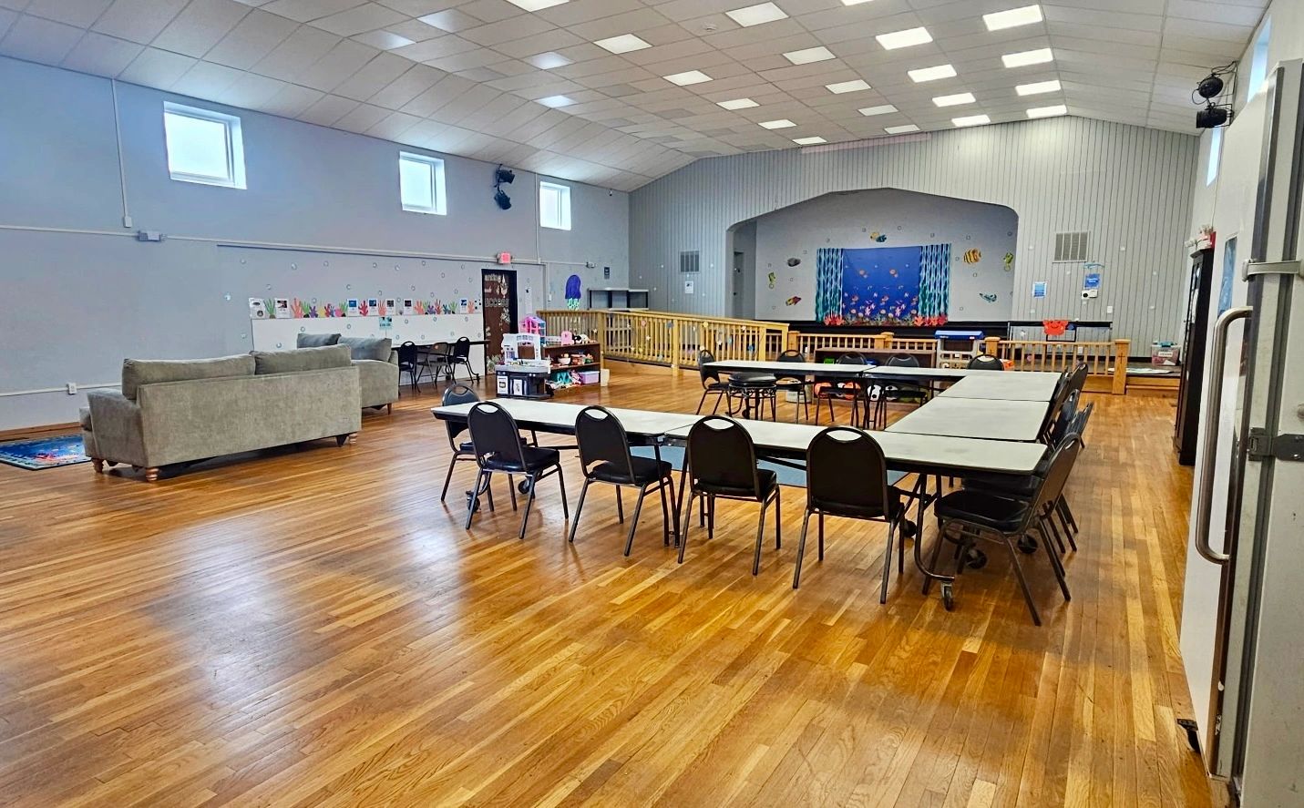 Spacious hall with tables, chairs, and couches.