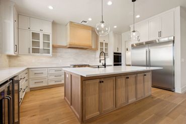 Modern kitchen with wooden island and stainless steel appliances.