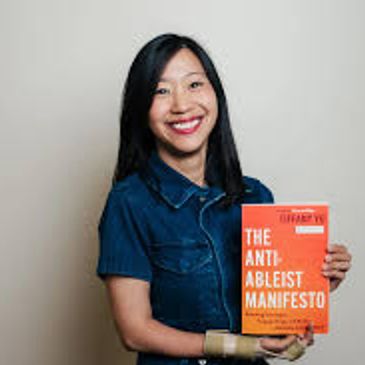 Tiffany Yu, an Asian American woman with long black hair, smiles while holding her book.
