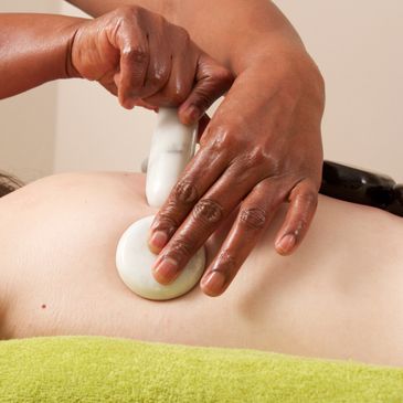 Female client doing hot stone back massage