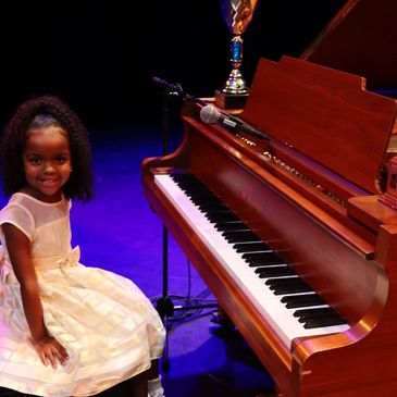 Young piano student performing at Lester B. Pearson Theatre with Synergy Music Academy