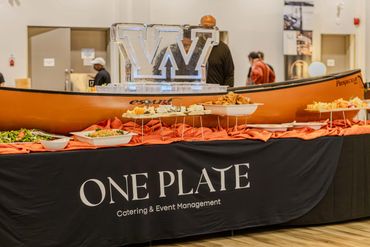 Catering setup with food trays and an ice sculpture centerpiece.