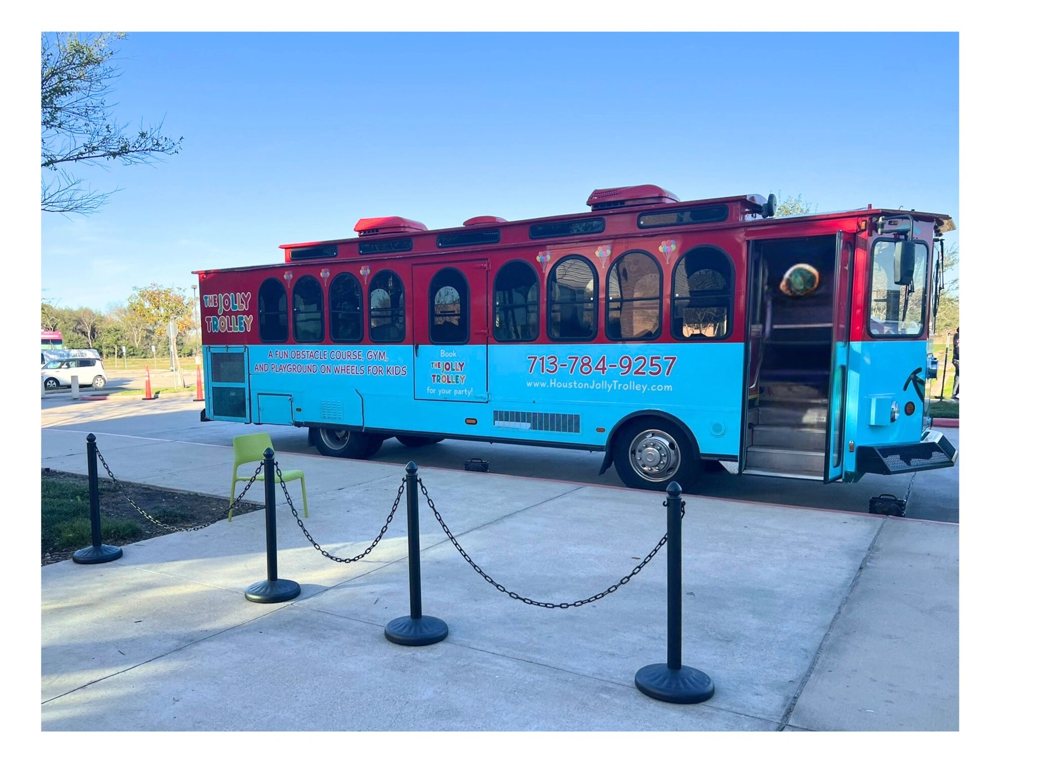 Colorful Jolly Trolley bus parked outdoors on a sunny day.