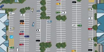 Aerial view of a busy parking lot with cars and trees.