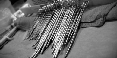 Black and white image of surgical instruments laid out on a table.