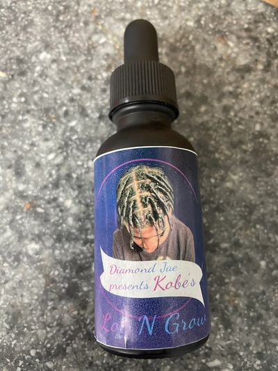 Black bottle with blue label, Diamond Jae presents Kobe’s Loc n grow.