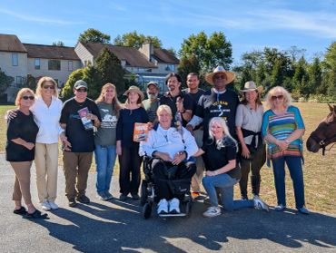 Group photo of diverse people outdoors on a sunny day.