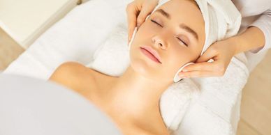 Female getting facial while lying on bed.