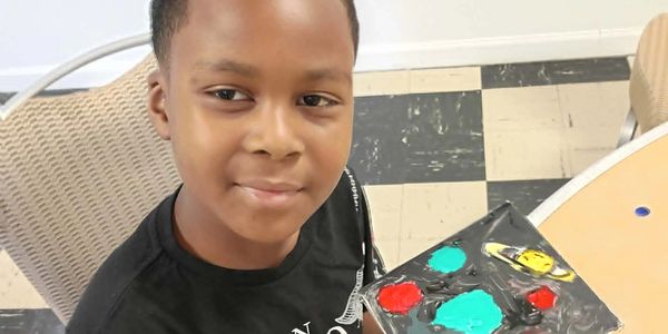Boy holding a painted art project.