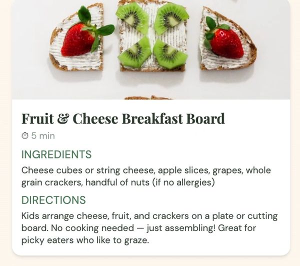 Fruit and cheese breakfast board with strawberries and kiwi on crackers.